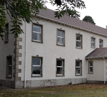 Exterior of a two-storey rendered building with multiple sash windows